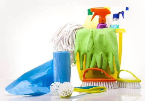 Domestic cleaner carrying out kitchen and bathroom cleaning in Finchley