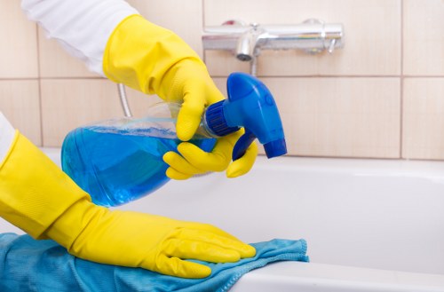 Professional cleaner using equipment for upper-storey windows in Finchley