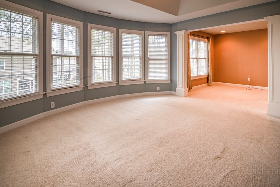 A bright, narrow hallway inside a residential building with white walls on the upper half and blue paneling on the lower half, separated by a white decorative chair rail. The area features a white fro